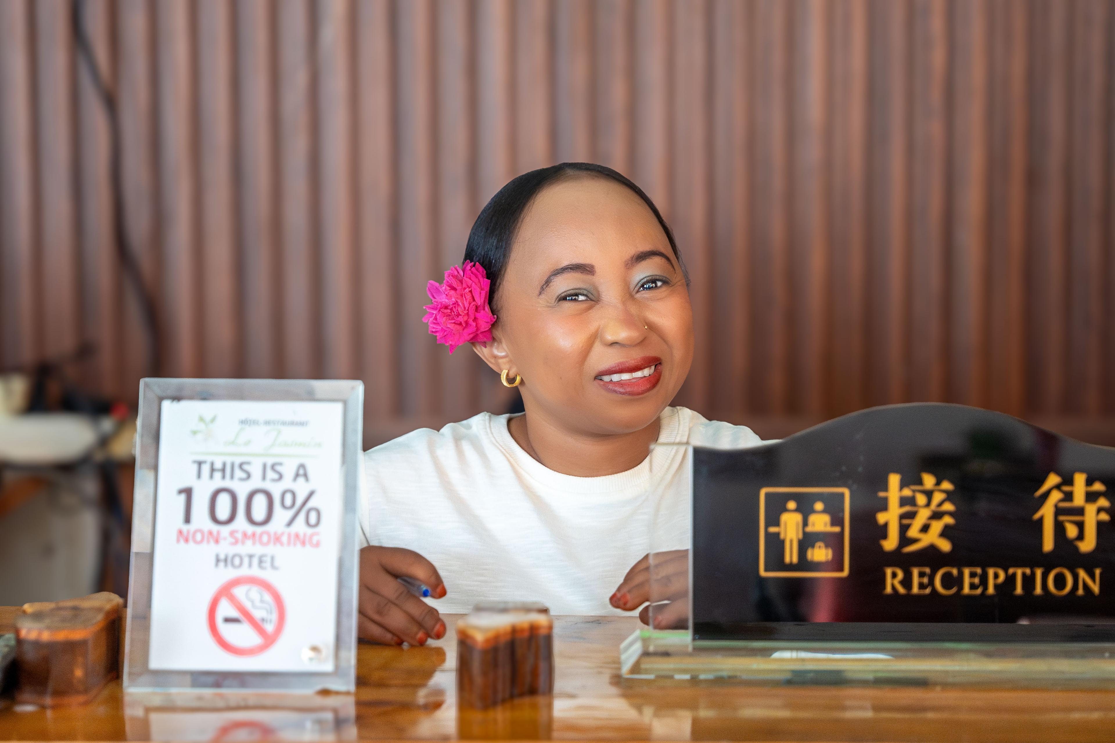 Équipe de réception souriante à l’accueil de l’Hôtel Le Jasmin