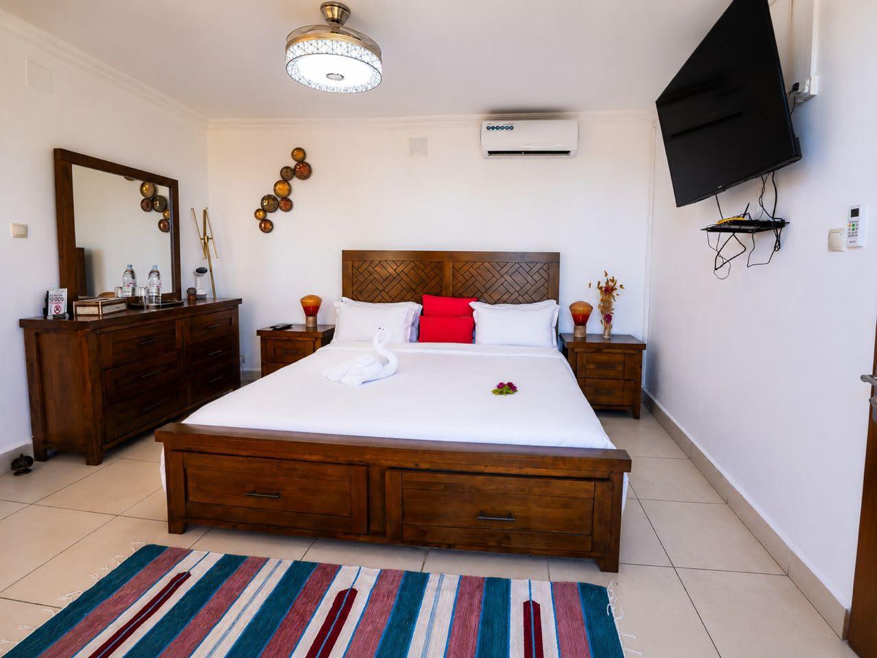 Chambre spacieuse de l'appart-hôtel avec grand lit en bois